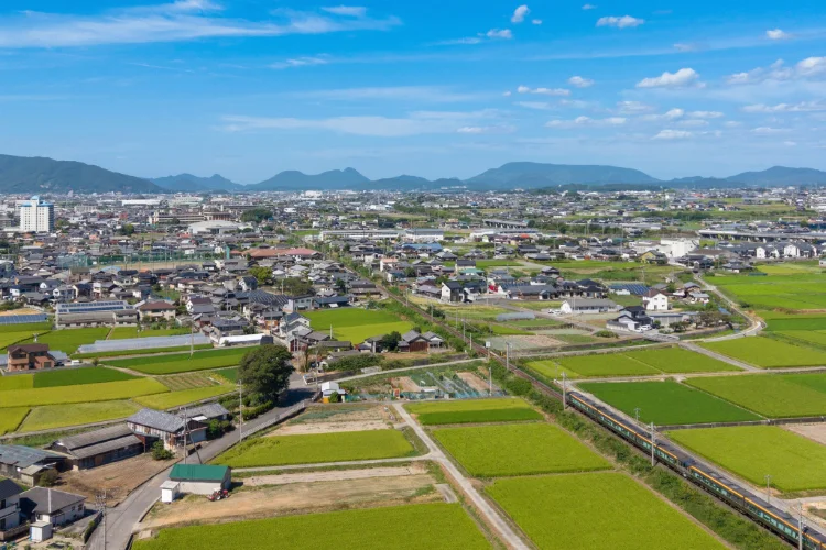観音寺市豊浜町和田の田園とJR予讃線を走る特急しおかぜをドローンで上空から撮影したPhoto