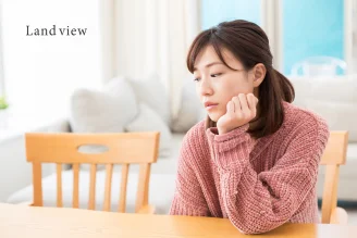 空き家や未利用不動産の管理に不安を感じる方のイメージ 将来の活用や維持管理に悩む様子 Land view