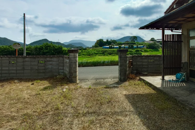 物件紹介 三豊市高瀬町佐股の売土地｜約141.57坪の敷地出入口と前面道路・田園風景を示す現地写真｜株式会社Land view（ランドビュー）